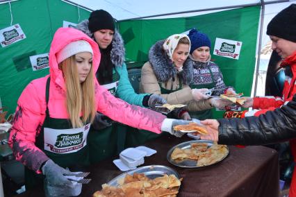 Масленица в Новосибирске. Девушки раздают блины во время праздничных гуляний.