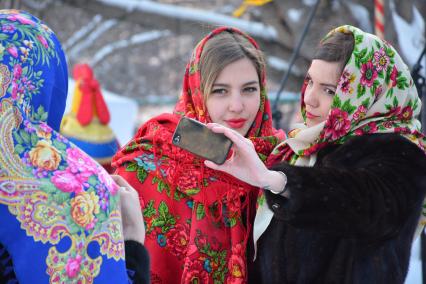 Масленица в Новосибирске. Девочки елают селфи во время праздничных гуляний.