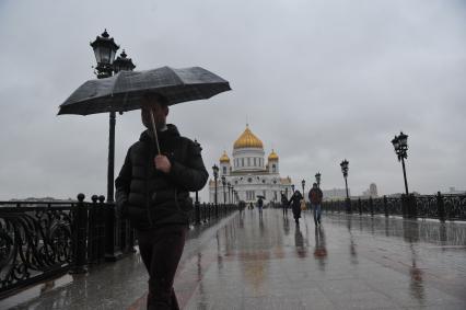 Москва.  Прохожие идут по  Патриаршему мосту  во время дождя.