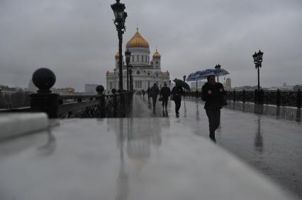 Москва.  Прохожие идут по  Патриаршему мосту  во время дождя.