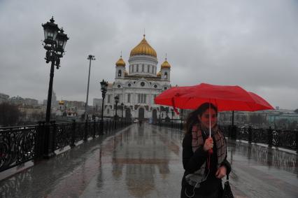 Москва.  Прохожие идут по  Патриаршему мосту  во время дождя.