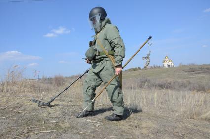 Волгоград. Сапер специальной мобильной группы разминирования отдельной бригады инженерных войск ЮВО с защитном костюме `Сокол` ищет с помощью искателя `Коршун` и миноискателя ИМПС-2 снаряды и мины времен Сталинградской битвы на территории `Мамаева кургана`.