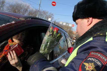 Нижний Новгород. Сотрудники ДПС дарят женщинам-водителям цветы в честь праздника восьмого марта.