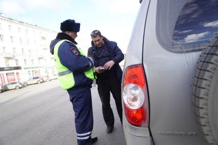 Екатеринбург. Сотрудник ДПС проверяет документы у водителя во время совместного рейда с судебными приставами по поиску должников.