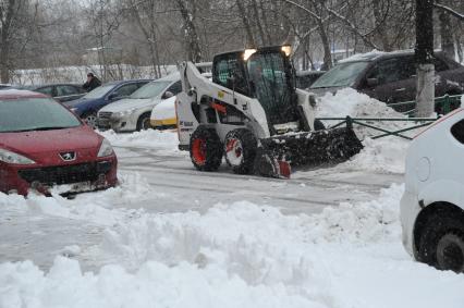 Москва.  Работа снегоуборочной техники на одной из улиц города после сильного снегопада.