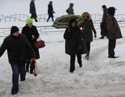 Москва.  Пешеходы идут по рыхлому снегу на одной из улиц города.