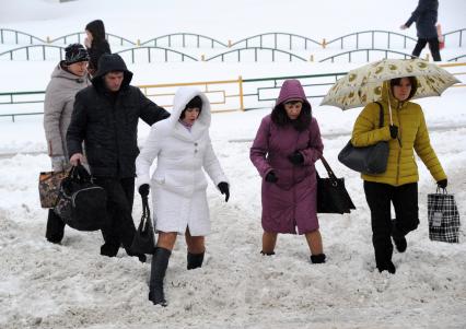 Москва.  Пешеходы идут по рыхлому снегу на одной из улиц города.