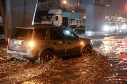 Москва. Автомобили едут по улице, затопленной в результате сильного дождя.