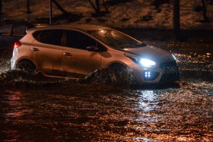 Москва. Автомобили едут по улице, затопленной в результате сильного дождя.