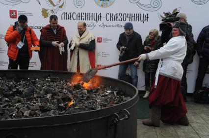 Москва.  Участники масленичных гуляний  во время приготовления блина диаметром три метра в саду `Эрмитаж`.