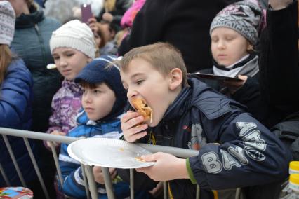 Ставрополь. Дети едят блины на празднике Широкой Масленицы