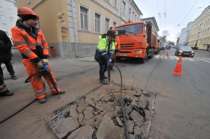 Москва.  Корреспондент `Комсомольской правды` Олег Адамович (в центре) во время выполнения работ по ямочному ремонту дорог  на улице Николоямская.