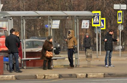 Москва.  Пассажиры на автобусной остановке.