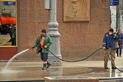 Москва. Сотрудник коммунальной службы моет тротуар на Тверской улице.