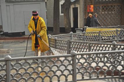 Москва.  Сотрудник коммунальной службы моет  тротуар на Патриарших прудах.