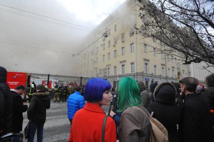 Москва.  Люди наблюдают за тушением пожара в здании Министерства обороны России на улице Знаменка.