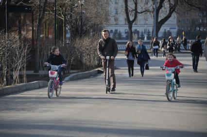 Москва.  Девочки катаются на велосипедах в Парке Горького.