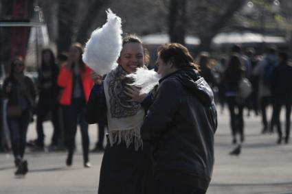 Москва.  Молодые люди   едят сахарную вату в Парке Горького.