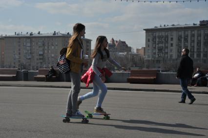 Москва.  Девушки катаются на скейтбордах на Пушкинской набережной Парка Горького.