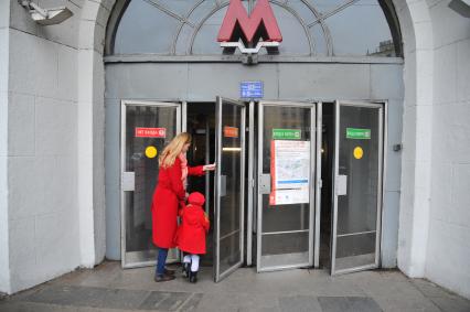 Москва.   Женщина с ребенком у входа на станцию метро  `Красные ворота`.