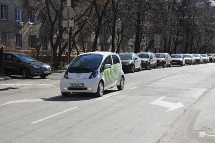 Москва. Водитель в автомобиле  Mitsubishi i-MiEV, оборудованый мобильными комплексами фотовидеофиксации `Паркрайт`, чтобы контролировать зону платной парковки.