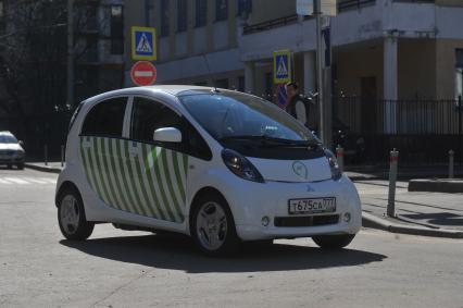 Москва. Водитель в автомобиле  Mitsubishi i-MiEV, оборудованый мобильными комплексами фотовидеофиксации `Паркрайт`, чтобы контролировать зону платной парковки.