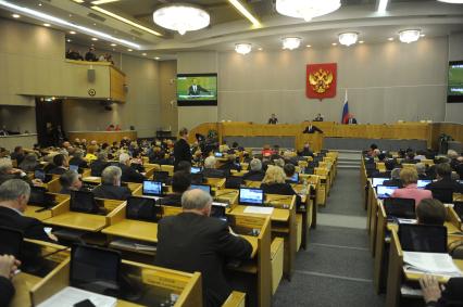 Москва.  Председатель правительства РФ Дмитрий Медведев  (в центре) во время выступления на пленарном заседании Государственной думы РФ.