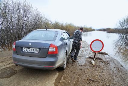 Свердловская область, деревня Махнево. Водитель у дороги затопленой во время разлива реки Тагил.