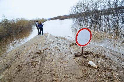 Свердловская область, деревня Махнево. Дорожный знак `Движение запрещено` на дороге, затопленой во время разлива реки Тагил.