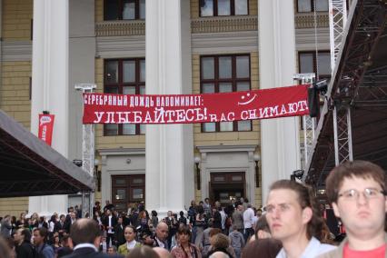 Диск100. Церемония вручения премий за самое сомнительное произведение искусства прошедшего года СЕРЕБРЯНАЯ КАЛОША. 2009 год. На снимке: транспорант СЕРЕБРЯНЫЙ ДОЖЬ НАПОМИНАЕТ: УЛЫБАЙТЕСЬ! ВАС СНИМАЮТ!