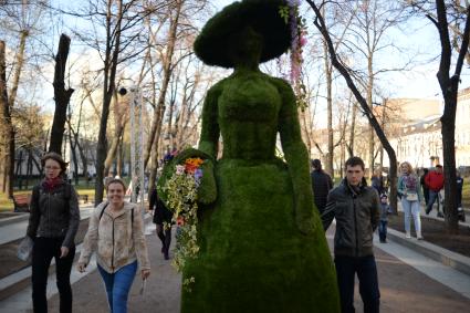 Москва. Участники парада цветов на Тверском бульваре рядом со скульптурами из живых цветов.