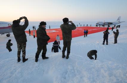 Северный полюс. Полярники фотографируют копию  знамени Победы , которую доставили и развернули на Северном полюсе делегаты миротворческой миссии `Самое большое знамя Победы`