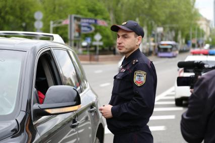 Украина, Донецк. Сотрудник ГАИ Донецкой народной республики проверяет документы у водителя.