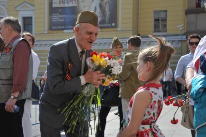 Москва. Девочка поздравляет ветерана   на улице  города во время праздничных гуляний, посвященных 71-й годовщине Победы в Великой Отечественной войне .