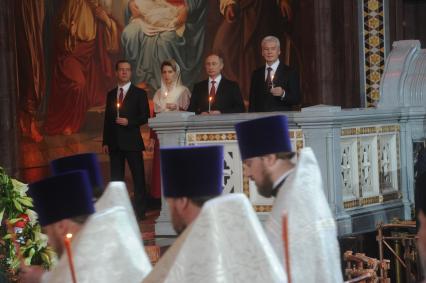 Москва. Председатель правительства РФ Дмитрий Медведев (слева) с упругой Светланой, президент РФ Владимир Путин (второй справа) и мэр Москвы Сергей Собянин (справа) на праздничном пасхальном богослужении в Храме Христа Спасителя.