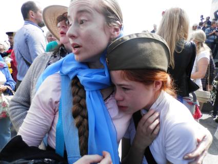 Украина, Киев. Мама с девочкой, с одежды которой агрессивно настроенные мужчины в камуфляже сорвали георгиевкую ленточку во время празднования Дня Победы.