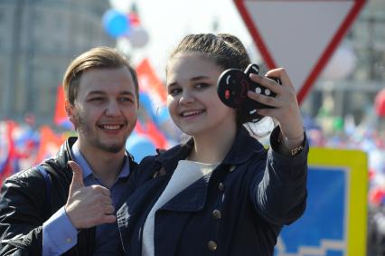 Москва.    Молодые люди фотографируются во время шествия профсоюзов, посвященного Дню международной солидарности трудящихся, празднику Весны и Труда.