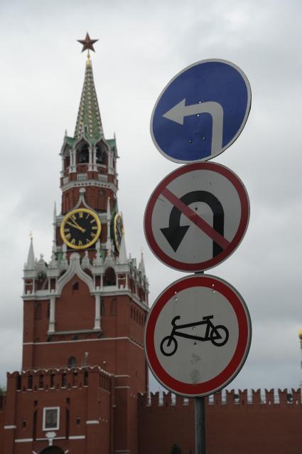 Москва. Дорожные знаки -  поворот налево , разворот запрещен и запрет велосипедистам у Спасской башни Кремля.