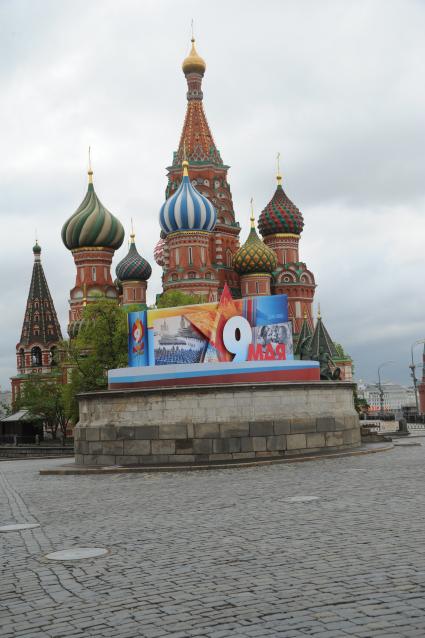Москва. Храм Василия Блаженного и Лобное место , украшенное к празднику 9 мая плакатом , на красной площади.