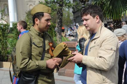 Москва. Корреспондент `Комсомольской правды` Павел Клоков (справа) выбирает пилотку.