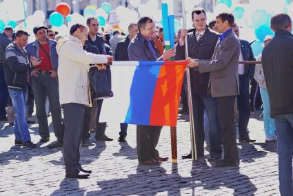 Екатеринбург. Празднование дня весны и труда 1 мая. Участники демонстрации сворачивают флаг России после шествия