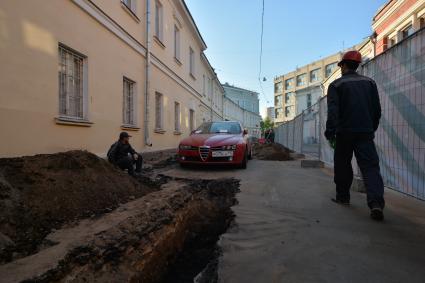 Москва. Машина в  Калашном  переулке  оказалась зажата между двумя траншеями и забором из-за внезапно начавшегося ремонта.