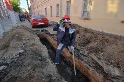 Москва. Машина в  Калашном  переулке  оказалась зажата между двумя траншеями и забором из-за внезапно начавшегося ремонта.