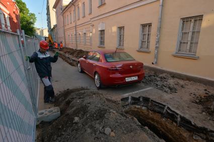 Москва. Машина в  Калашном  переулке  оказалась зажата между двумя траншеями и забором из-за внезапно начавшегося ремонта.