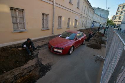 Москва. Машина в  Калашном  переулке  оказалась зажата между двумя траншеями и забором из-за внезапно начавшегося ремонта.