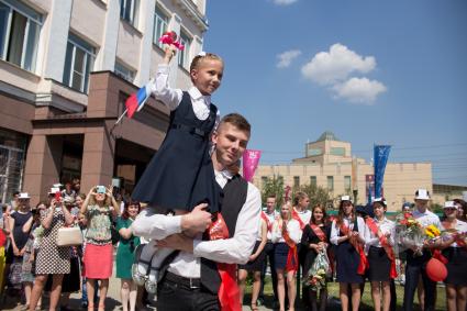 Челябинск. Последний звонок в школе. Первоклассница звонит в колокольчик.