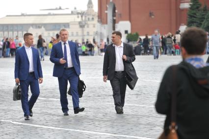 Москва.  Мужчины прогуливаются по  Красной площади в районе Никольской улицы.