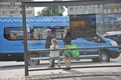 Москва.  Маршрутное такси компании ООО `Автокарз`   на остановке.