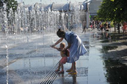 Москва.    Девушка с ребенком в фонтане в парке искусств `Музеон`.