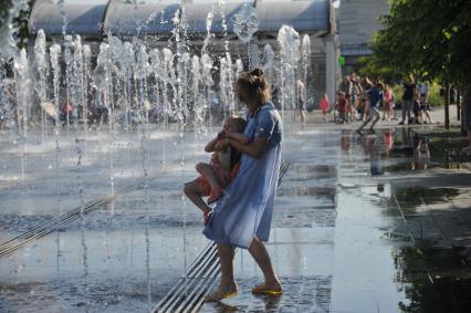 Москва.    Девушка с ребенком в фонтане в парке искусств `Музеон`.